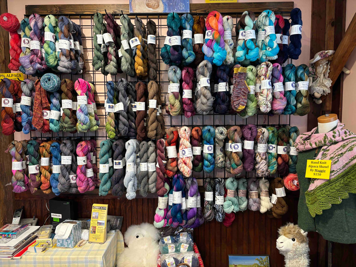 a wall of alpaca yarn for sale in our farm store